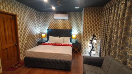 a bedroom with a bed and a couch at Royal Luxury Hotel Lahore in Lahore