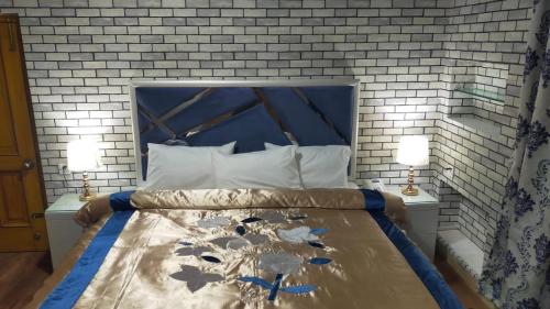 a bedroom with a bed with a blue headboard and two lamps at Royal Luxury Hotel Lahore in Lahore