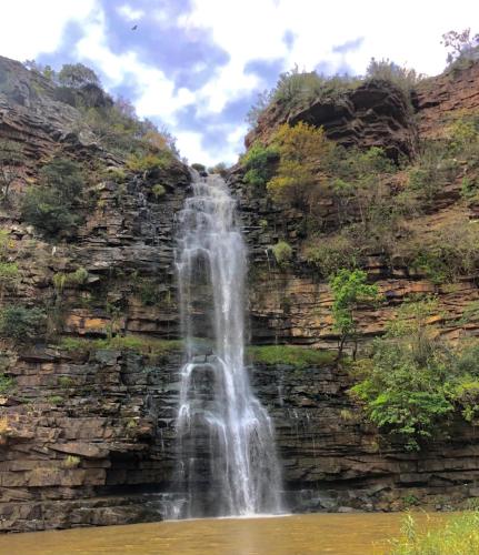 a waterfall on the side of a rock wall at Ezweni Lodge in Inanda