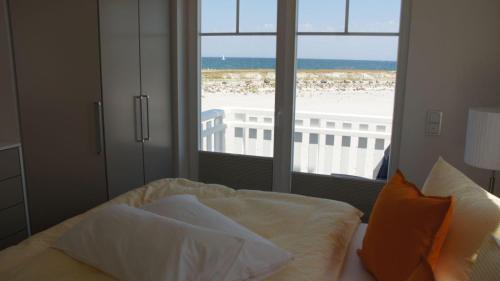 a bedroom with a bed and a view of the beach at Ostseeperle in Kappeln