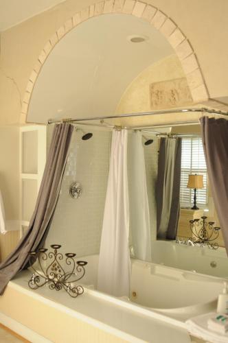 a bathroom with a large mirror and a tub at Acorn Hill Lodge and Spa in Lynchburg