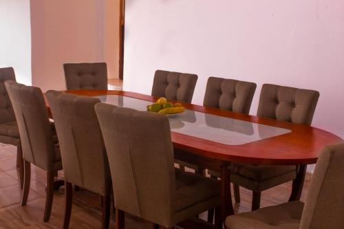 una mesa de comedor con sillas y un bol de fruta. en Ocean View Guesthouse, en São Tomé