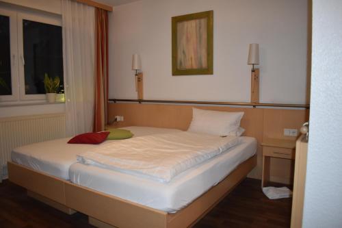 a large bed in a room with a window at Hotel Alte Post Ostbevern in Ostbevern