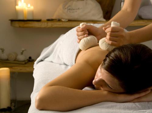 a woman is laying on a bed with her feet inombie at Chalet Jochpass Ferienwohnungen by HOTEL LANIG - Ferienwohnungen mit Zugang zum WellnessSpa im Hotel Lanig in Bad Hindelang