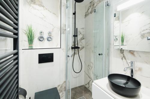a bathroom with a black toilet and a shower at Luisenstudio in Norderney