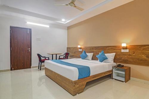 1 dormitorio con 1 cama, mesa y sillas en The Balcony Hotel en Hyderabad