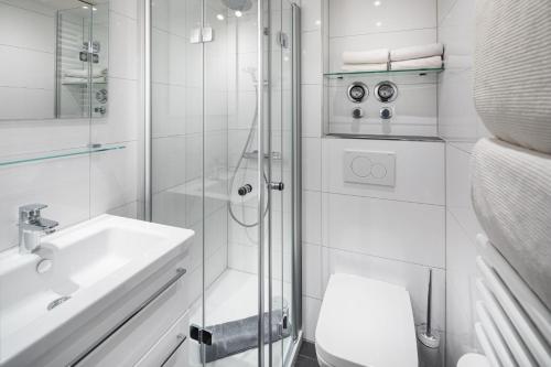 ein Bad mit einer Dusche, einem WC und einem Waschbecken in der Unterkunft Die Kogge - Wohnung 9 in Norderney