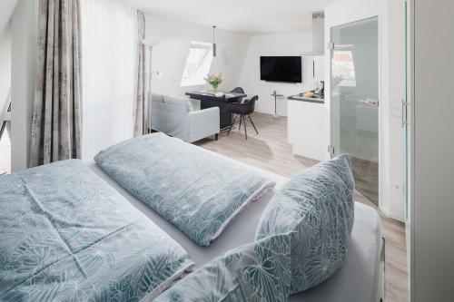 - une chambre avec un lit doté d'oreillers bleus dans l'établissement Luisensuite, à Norderney