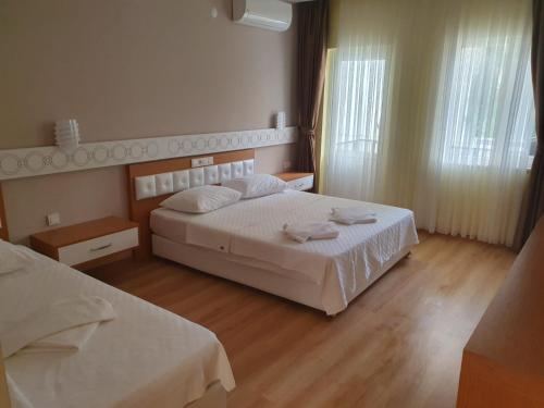 a hotel room with two beds and two windows at Terko hotel pansiyon in Beldibi