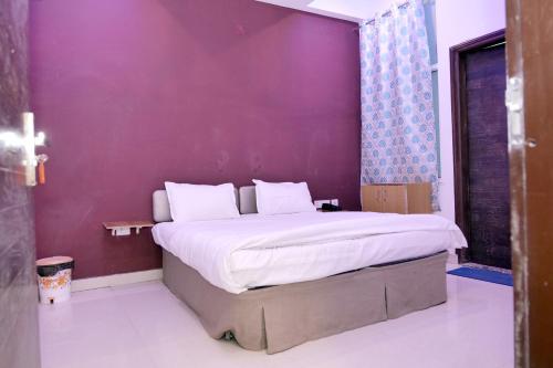 a bedroom with a large bed with a purple wall at HOTEL IRA Mansarovar Jaipur in Jaipur