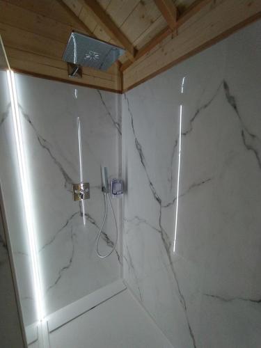 ein Badezimmer mit Marmorwänden und einer Dusche mit Licht in der Unterkunft La cabane au bain perché 