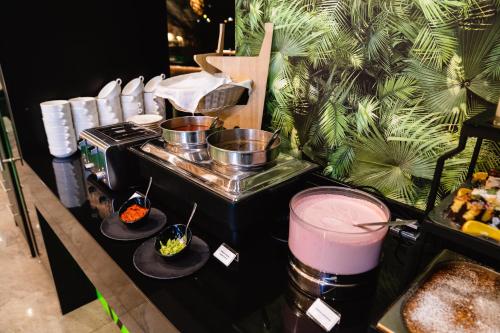 a buffet with pots and pans on top of a stove at Allure Healthy Hotel & Spa in Eger