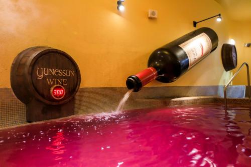 a bottle of wine being poured into a pool of pink water at Hakone Kowakien Hotel in Hakone