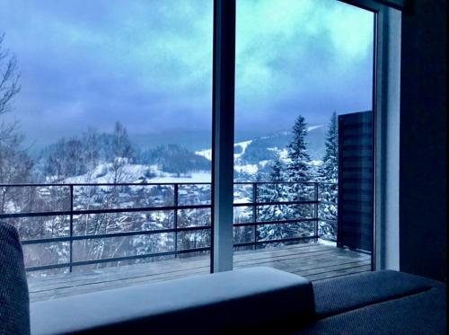 a room with a window with a view of a snowy mountain at Apartamenty Widokowe Na Szczycie in Korbielów