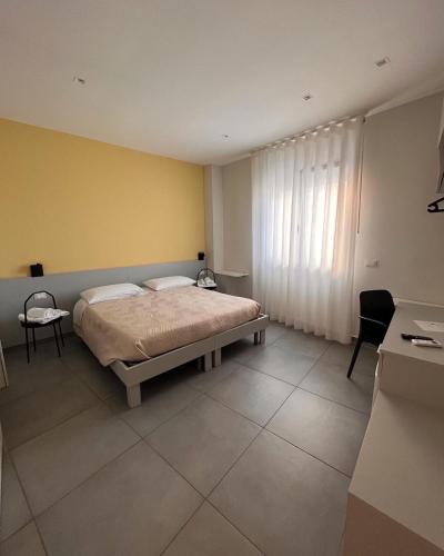 a bedroom with a bed and a yellow wall at Agathè Luxury Bed and Breakfast in Marina di Schiavonea