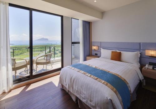 頭城的住宿－蘭陽烏石港海景酒店，一间带大床的卧室和一个阳台