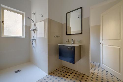 a bathroom with a sink and a mirror at Idyllic Apartment close to Valletta in Il-Furjana