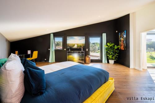 una camera da letto con un grande letto con lenzuola blu di Villa Eskapi Perpignan a Perpignano