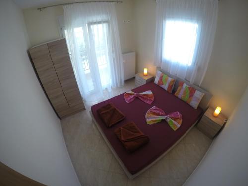 メタモルフォシにあるDimi Apartmentsのベッドルーム(紫色のベッド、弓付)