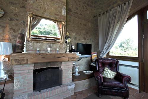 een woonkamer met een stoel en een open haard bij Casa Sandro a Podere Pascianella in Castelmuzio