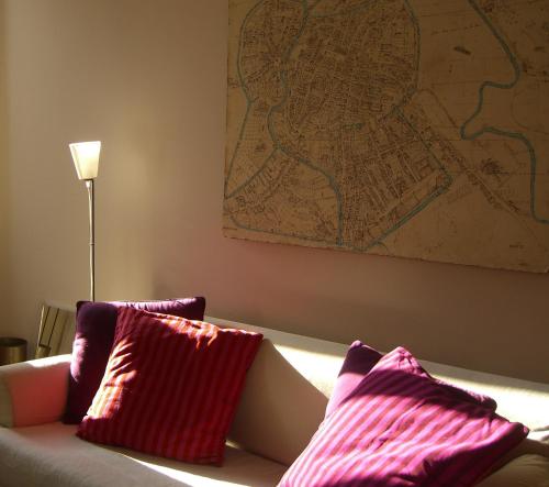 a couch with two pillows and a map on the wall at Il Palazzetto in Vicenza