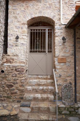 a stone building with a door and a window at Dandy Villas Dimitsana - a family ideal charming home in a quaint historic neighborhood - 2 fireplaces for romantic nights in Dhimitsana