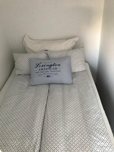 Una cama blanca con una almohada encima. en Leilighet ved Tønsberg Brygge - Rambergveien 18, en Tønsberg