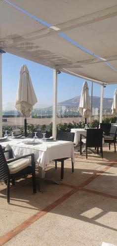 a patio with white tables and umbrellas and chairs at mArinAr in Agadir