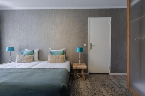 a bedroom with a large bed and a mirror at Boutique Hotel Slenaker Vallei - Buitengewoongenieten in Slenaken