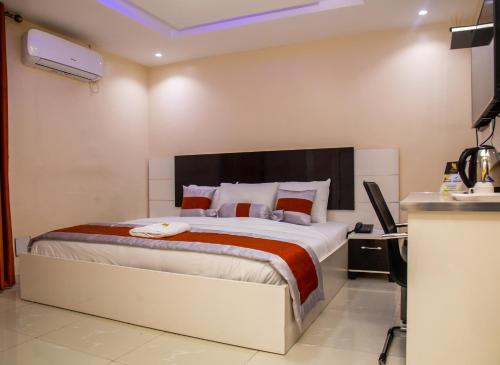 a bedroom with a bed and a desk with a computer at Appleville Suites in Ikeja