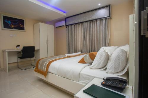 a bedroom with a bed and a desk with a keyboard at Appleville Suites in Ikeja