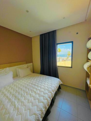 a bedroom with a large bed and a window at Appart Hôtel Pyramides El Jadida in El Jadida