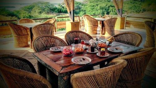 ein Holztisch mit Stühlen und Essen darauf in der Unterkunft La Kamp Resort in Bhuj