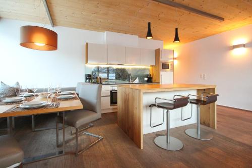 cocina con mesa, sillas y barra en Appartements Waluliso by Schladming-Appartements en Schladming