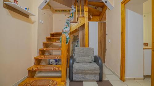 a living room with a staircase and a chair at Apartament Simon Brasov in Braşov