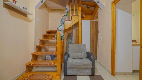Una sala de estar con una escalera y una silla. en Apartament Simon Brasov, en Brasov