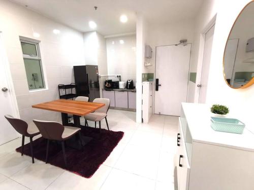 Il comprend une cuisine et une salle à manger avec une table et des chaises en bois. dans l'établissement Wincy Home Metrocity Kuching-N, à Kuching