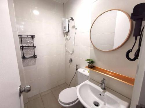 uma casa de banho com um WC, um lavatório e um espelho. em Wincy Home Metrocity Kuching-N em Kuching