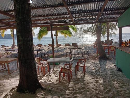 a group of tables and chairs on the beach at White Pearl Beach in Koh Rong