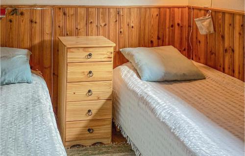 um quarto com 2 camas e uma parede de madeira em Awesome Home In Lttorp With Kitchen em Löttorp