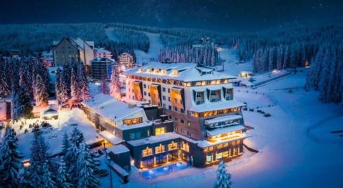 a large building in the snow at night at Milmari S70 Kopaonik in Kopaonik