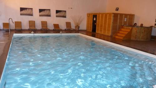 a large swimming pool in a room with chairs at Orelle 3 Vallées - 2 pièces 5 personnes in Orelle