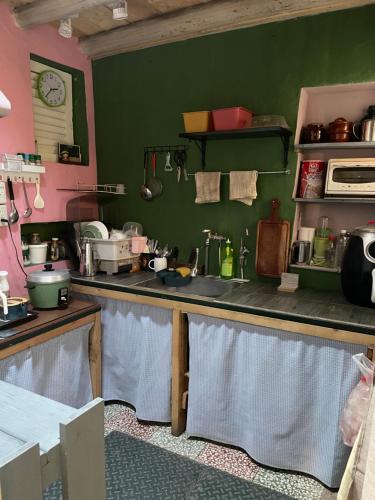 a kitchen with a counter and a green wall at Xinqin B&B - City Area in Jincheng