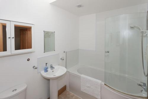 a white bathroom with a sink and a shower at Appletree Cottage at Williamscraig Holiday Cottages in Linlithgow