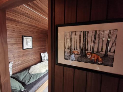a room with two beds and a picture on the wall at Idylliske Evjua ved Mjøsa in Skreia
