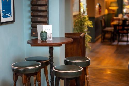 a small table with four stools in a room at Riverside Hotel by Chef & Brewer Collection in Burton upon Trent