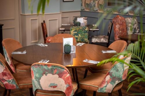 a wooden table and chairs in a room at Riverside Hotel by Chef & Brewer Collection in Burton upon Trent