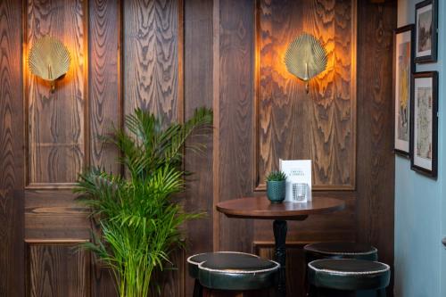 a table and stools in a room with wooden walls at Riverside Hotel by Chef & Brewer Collection in Burton upon Trent