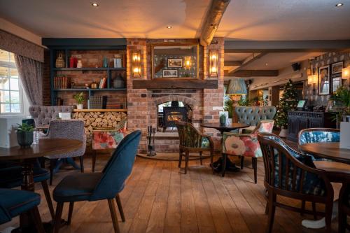a restaurant with tables and chairs and a fireplace at Riverside Hotel by Chef & Brewer Collection in Burton upon Trent