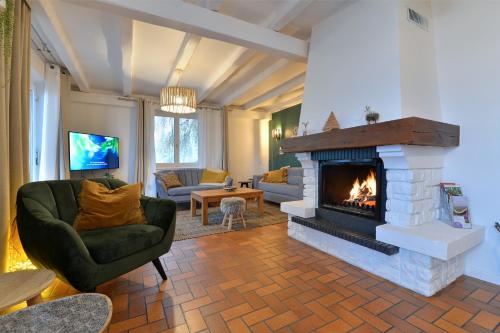 a living room with a fireplace and a couch and chairs at A l'Oree du Bois in Labaroche